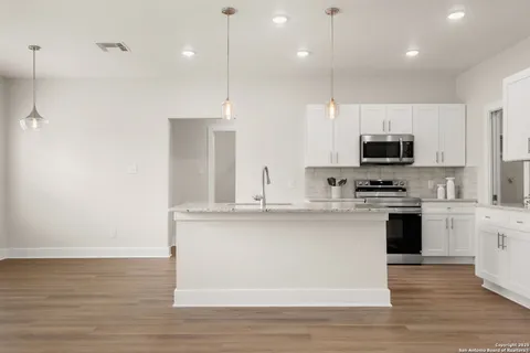 a kitchen with kitchen island a sink stainless steel appliances and cabinets