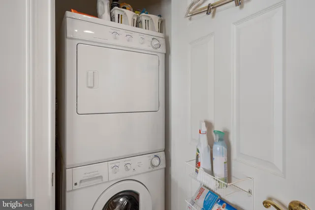 an empty room with chandelier fan and windows