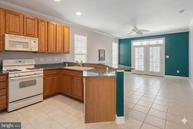 an empty room with kitchen view and a refrigerator