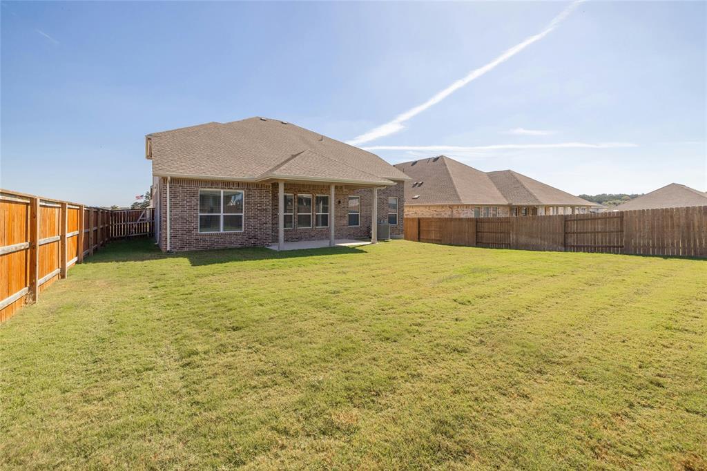113 Shadow Oak Cove Georgetown, TX 78628 - Photo 38 of 40 A spacious backyard enclosed by a durable wood fence, offering ample room for outdoor activities.