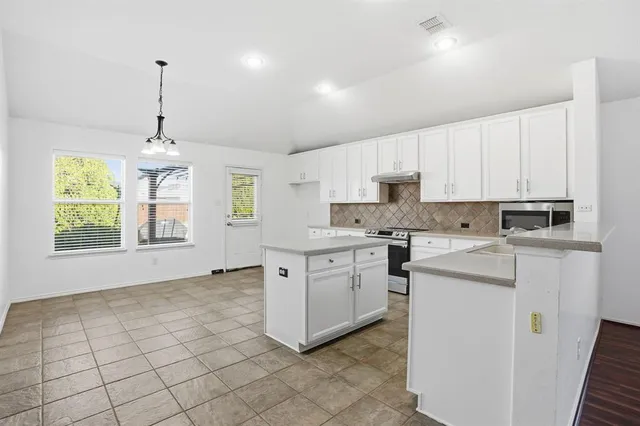 a kitchen with appliances cabinets and a window