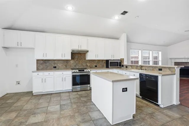 a kitchen with granite countertop a sink and white cabinets