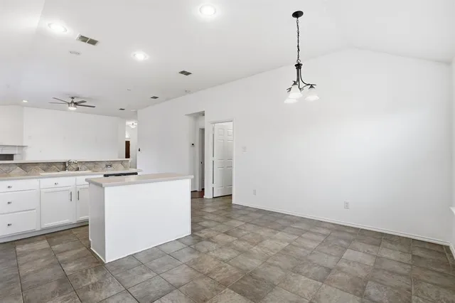 a kitchen with granite countertop white cabinets and white appliances