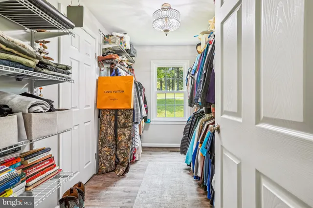a view of walk in closet with clothes and shoes