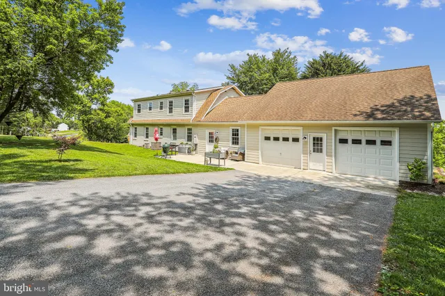 a view of an house with backyard and a tree