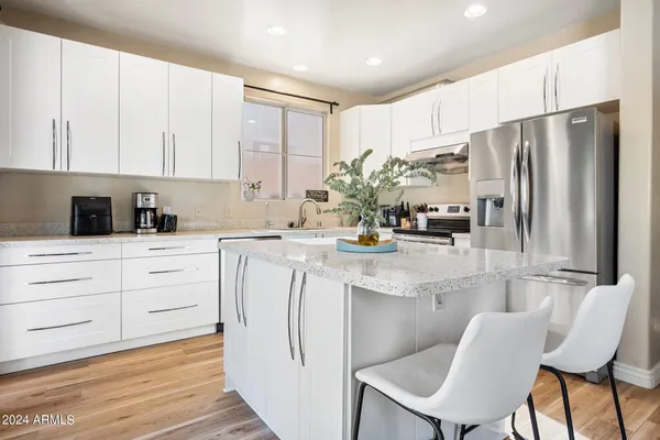 a kitchen with white cabinets and stainless steel appliances
