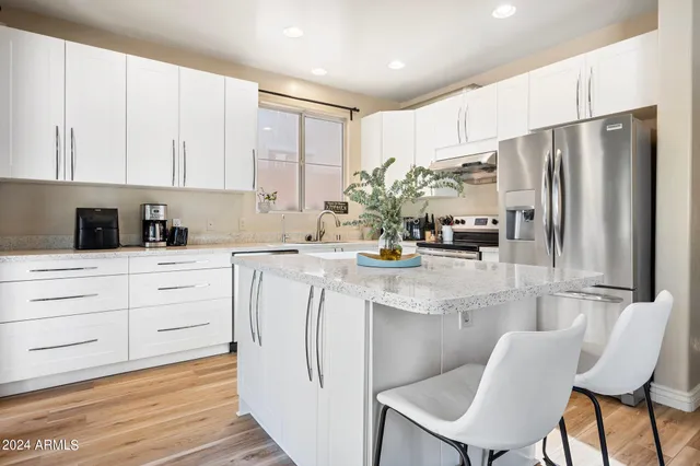 a kitchen with white cabinets and stainless steel appliances