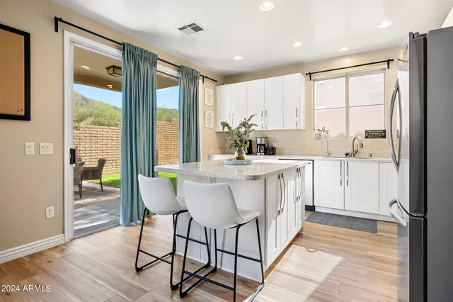 a dining room with stainless steel appliances a large window a sink and a refrigerator