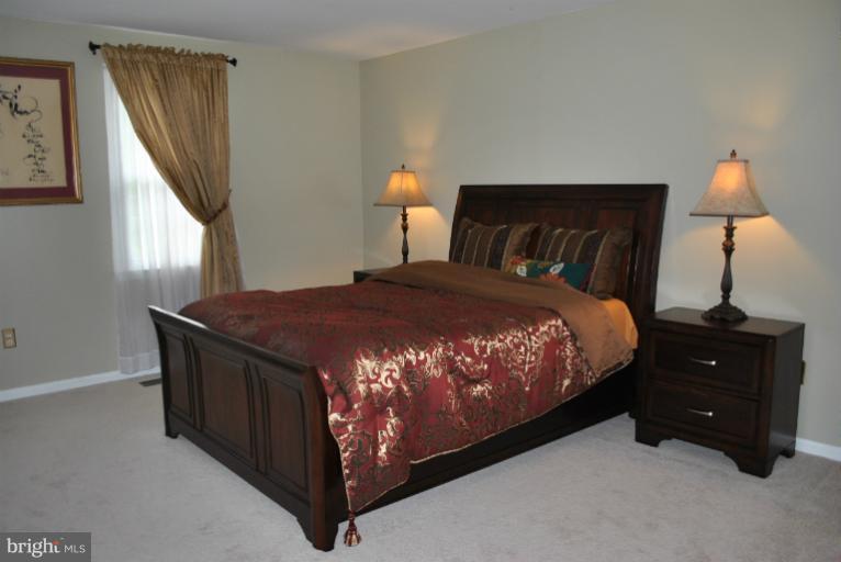 15317 Peach Orchard Road Silver Spring, MD 20905 - Photo 21 of 30 a bedroom with a bed window and a lamp