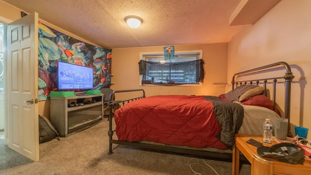 a bedroom with a bed and a painting on the wall