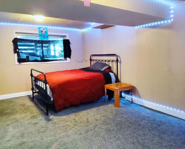 a bed sitting in a room next to a lamp