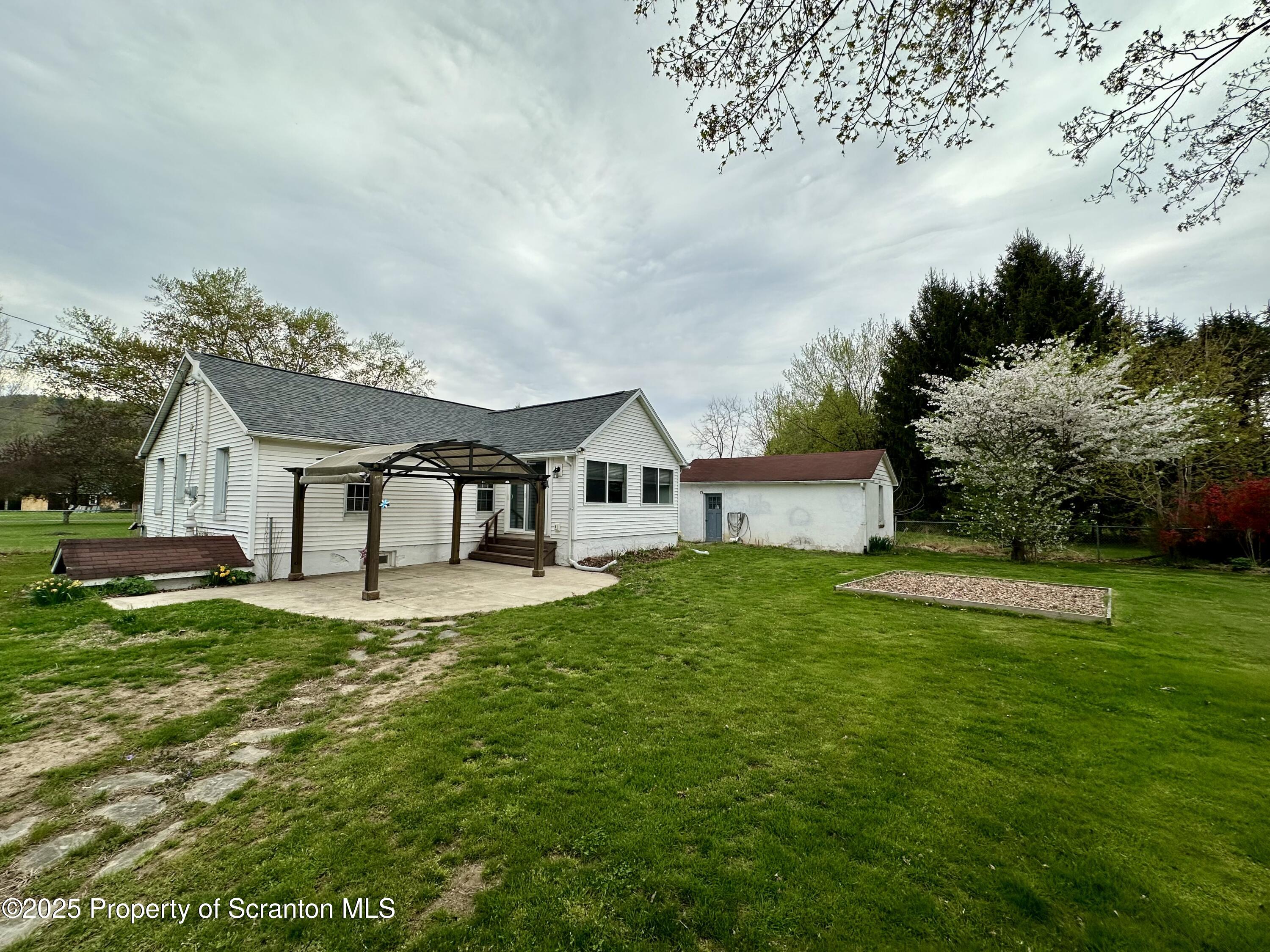 4 East Lemon Road Tunkhannock, PA 18657 - Photo 2 of 25 a house that is sitting in the grass with large trees and plants