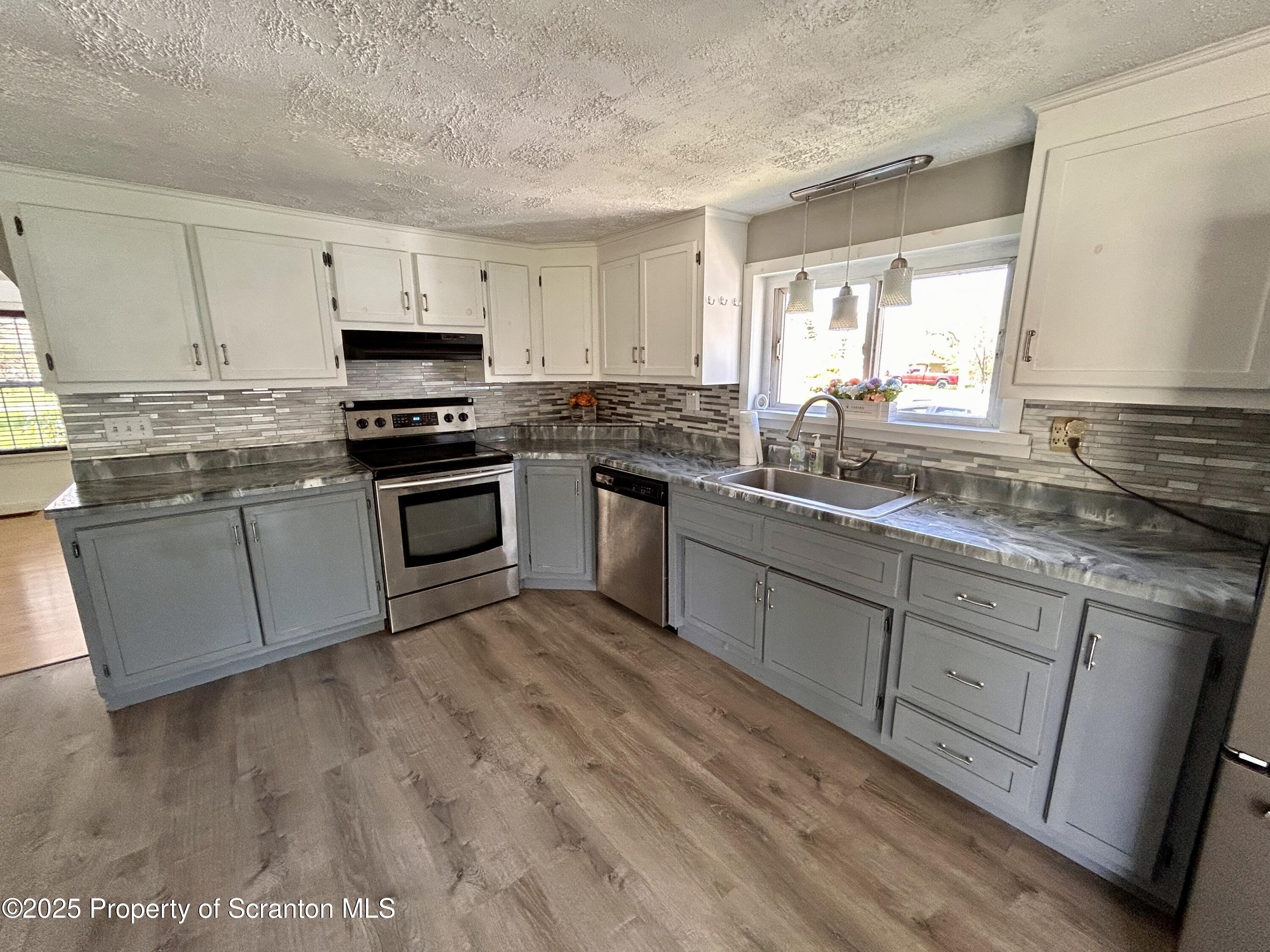 4 East Lemon Road Tunkhannock, PA 18657 - Photo 6 of 25 a kitchen with stainless steel appliances granite countertop a stove a sink and white cabinets