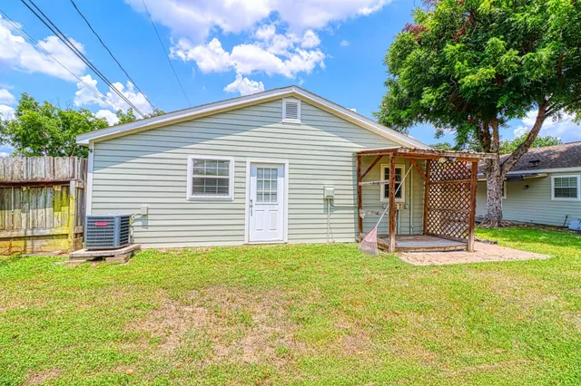 a front view of house with yard and trees in the background