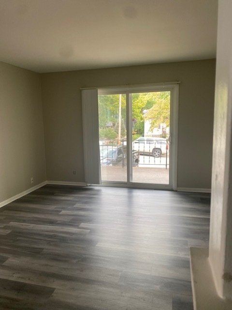 809 Vine Street Joliet, IL 60435 - Photo 3 of 8 a view of an empty room with wooden floor and a window