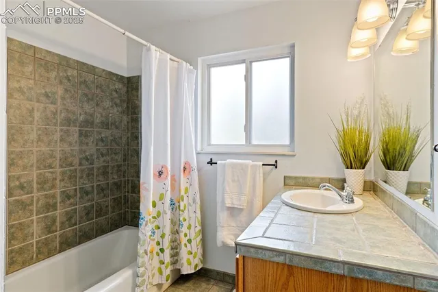 a bathroom with a tub sink and mirror