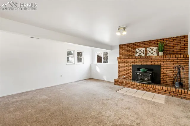 an empty room with a fireplace and window