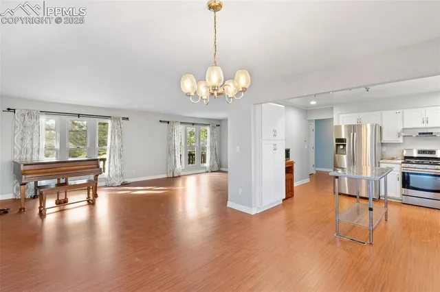 a view of a livingroom with furniture wooden floor a chandelier