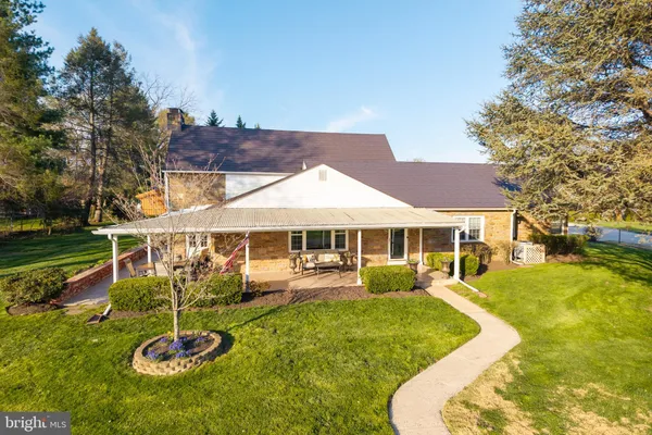 a view of a house with backyard and sitting area