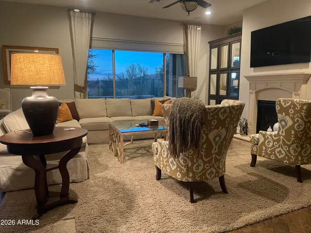 a living room with furniture a flat screen tv and a fireplace