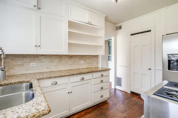 a kitchen with granite countertop white cabinets and sink