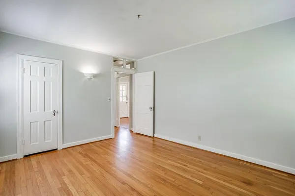 a view of an empty room with wooden floor