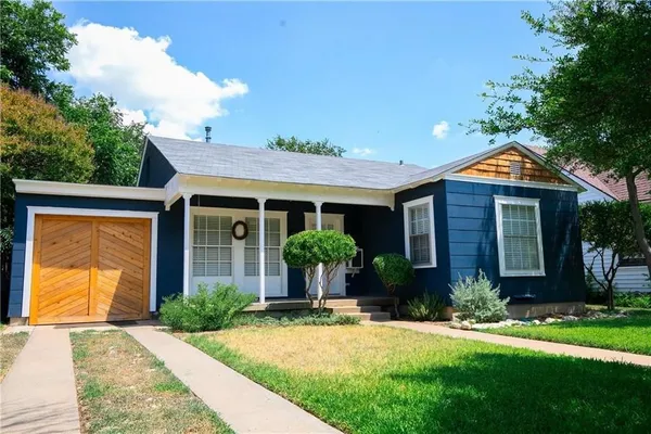 a front view of a house with yard and green space