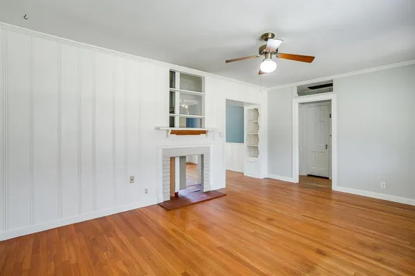 a view of a livingroom with wooden floor and a ceiling fan