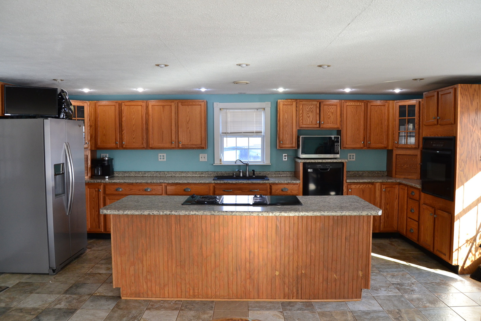 5126 Park Road Clinton, IL 61727 - Photo 3 of 25 a kitchen with kitchen island granite countertop a refrigerator a sink a stove top oven and a refrigerator