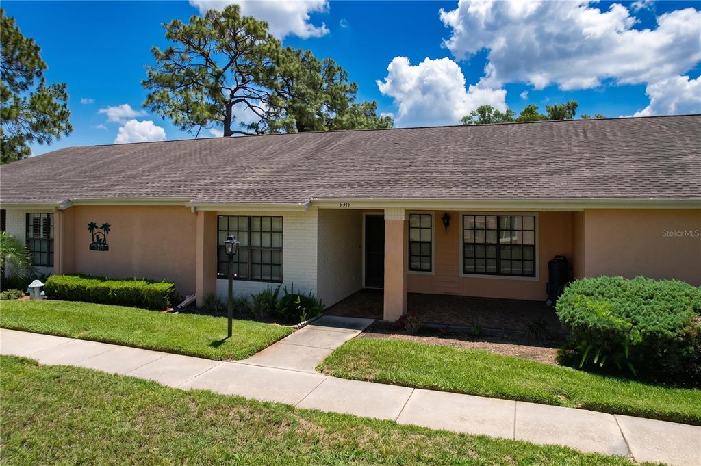 9319 Trowbridge Court New Port Richey, FL 34655 - Photo 3 of 78 a front view of a house with garden