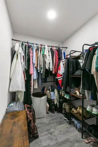 a view of walk in closet with clothes and shoes