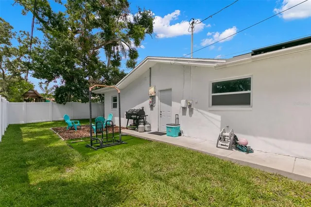a backyard of a house with table and chairs