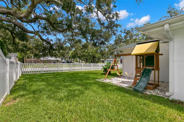 a view of a house with a backyard and a tree