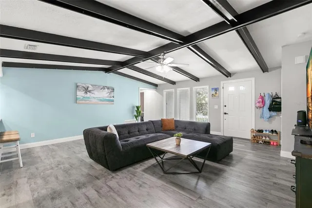 a living room with furniture and a wooden floor