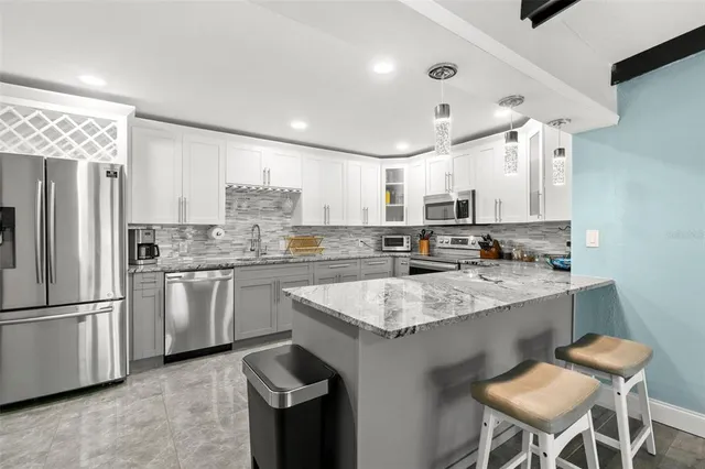 a kitchen with stainless steel appliances granite countertop a sink stove and refrigerator