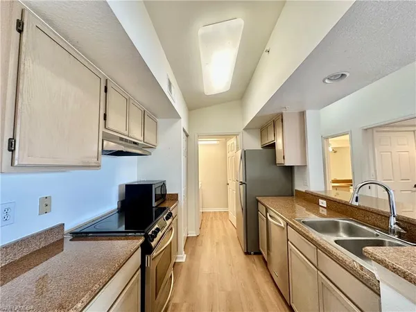 a kitchen with stainless steel appliances granite countertop a sink stove and refrigerator