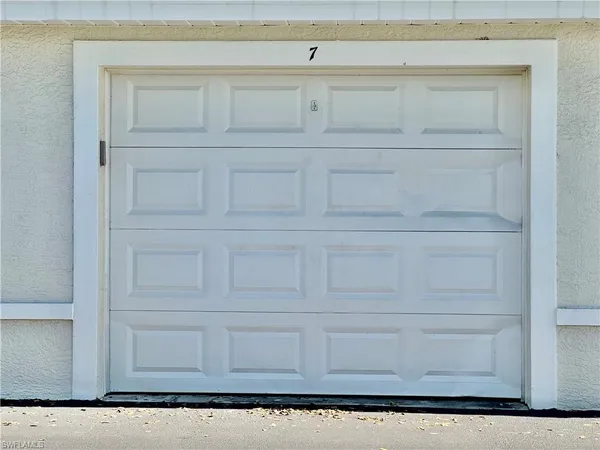 a row of palm trees in front of a house