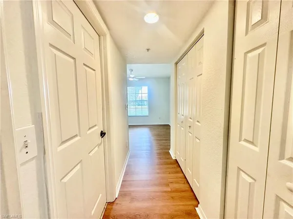 a view of a hallway with wooden floor and staircase
