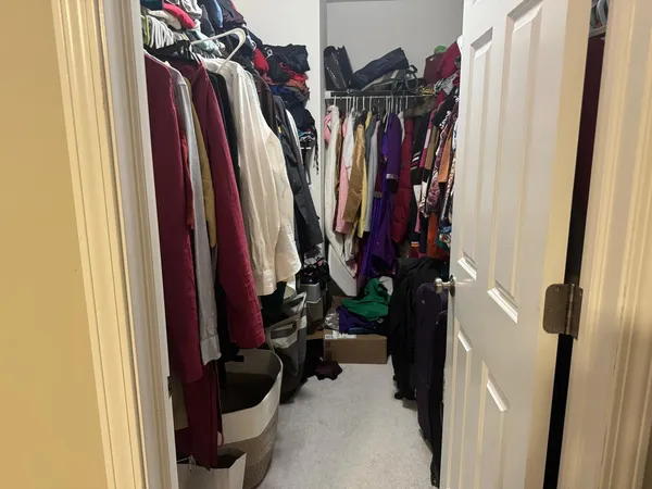 a view of walk in closet with clothes