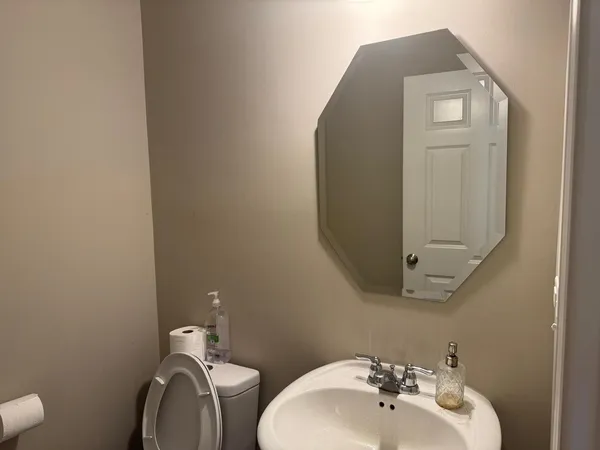 a bathroom with a toilet sink and mirror