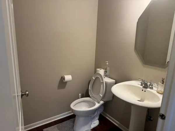 a bathroom with a toilet sink and mirror