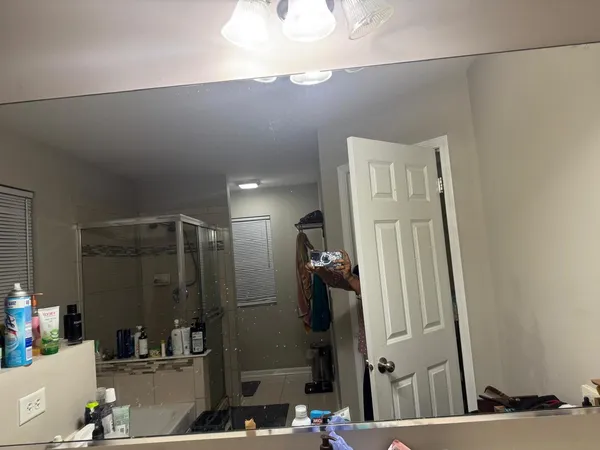 a bathroom with a mirror and a shower