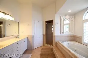 a spacious bathroom with a tub sink shower and mirror