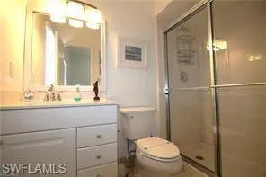 a bathroom with a sink a toilet a mirror and shower