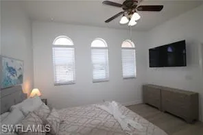 a bedroom with bed tv and window