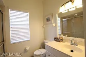 a bathroom with a sink a toilet and mirror