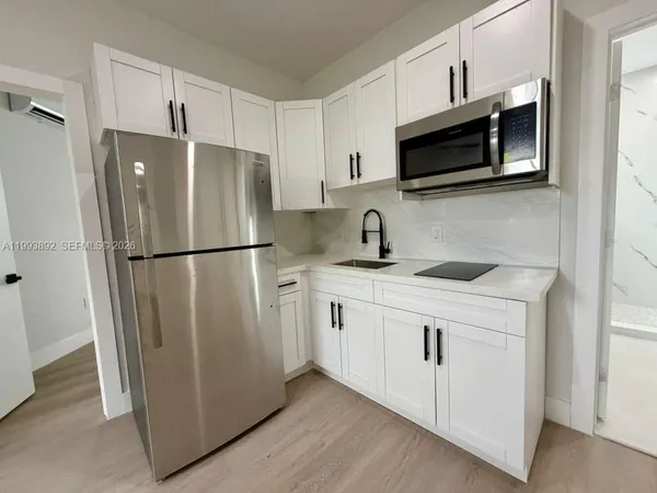 a kitchen with stainless steel appliances a refrigerator microwave and sink