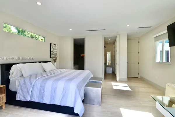 a bedroom with a bed and painting on the wall
