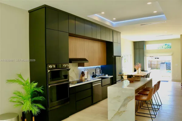 a kitchen with sink a counter and chairs