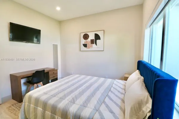 a bedroom with a bed and a flat screen tv